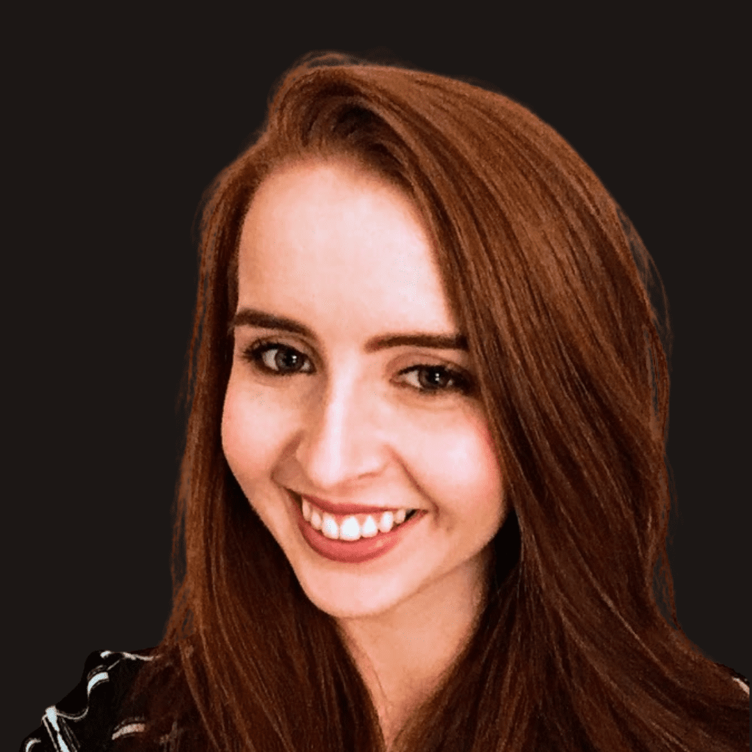 A young woman with long, straight auburn hair smiles at the camera against a solid black background. She is wearing a striped top, embodying the creative spirit of Ealaín na Gaeltachta.