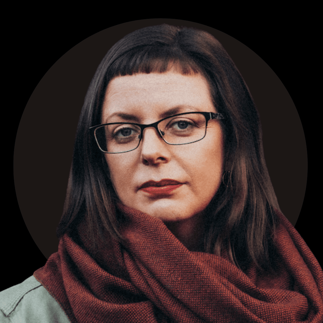 A woman with straight brown hair, wearing glasses and a red scarf, looks directly at the camera with a neutral expression. The dark, circular background evokes the mood of Ealaín na Gaeltachta.